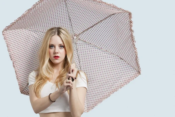 Frau mit gepunktetem Regenschirm — Stockfoto