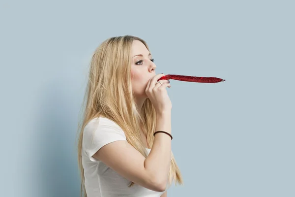 Young woman blowing party blower — Stock Photo, Image