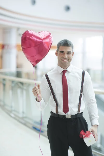 Geschäftsmann mit Luftballon und Geschenk — Stockfoto