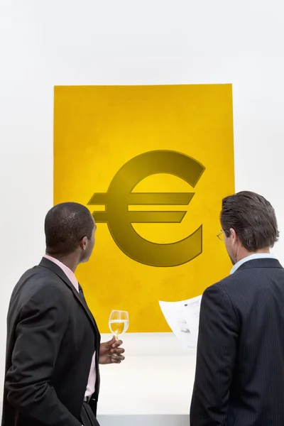 Male executive looking at Euro sign — Stock Photo, Image