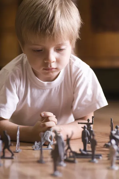 Jongen spelen met speelgoed soldaten — Stockfoto