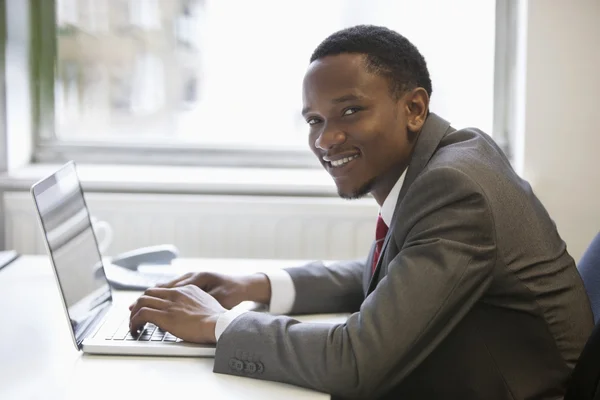 Empresário afro-americano usando laptop — Fotografia de Stock