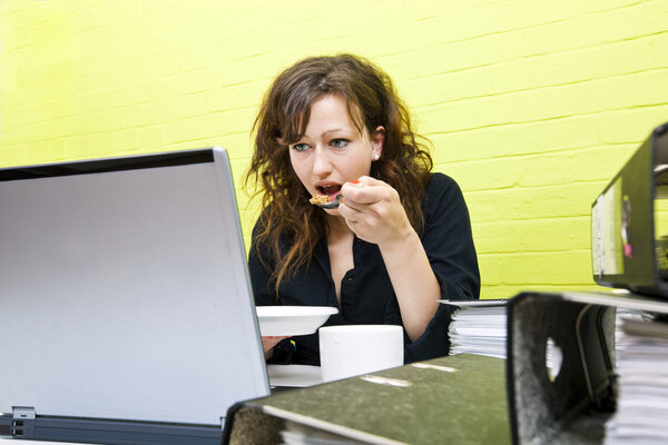 Woman eating and working