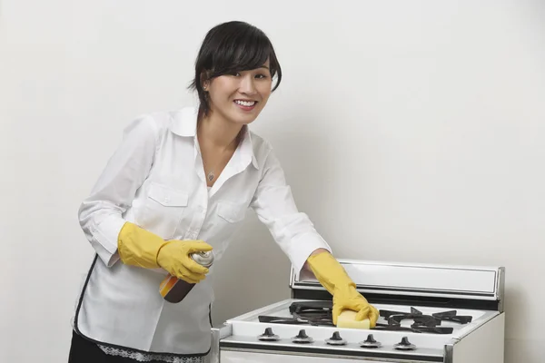 Maidservant cleaning stove — Stock Photo, Image