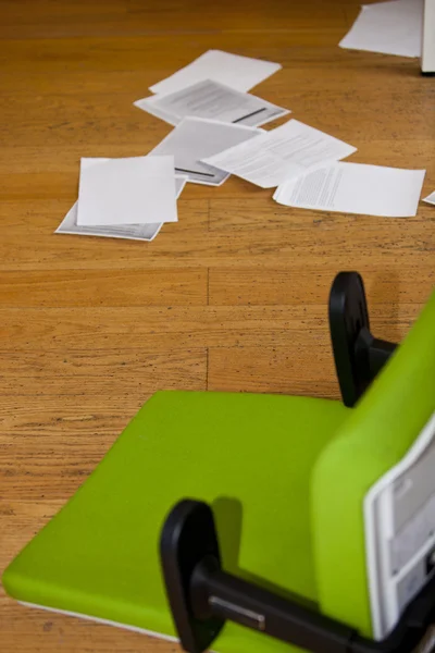 Stoel en papierwerk op de verdieping — Stockfoto