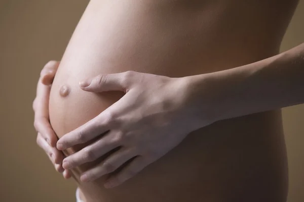 Žena s rukama na břiše — Stock fotografie