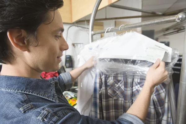 Hombre revisando ropa en Laundrette — Foto de Stock