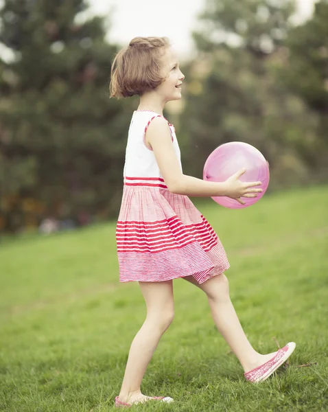 Mädchen spielt mit lila Ball — Stockfoto