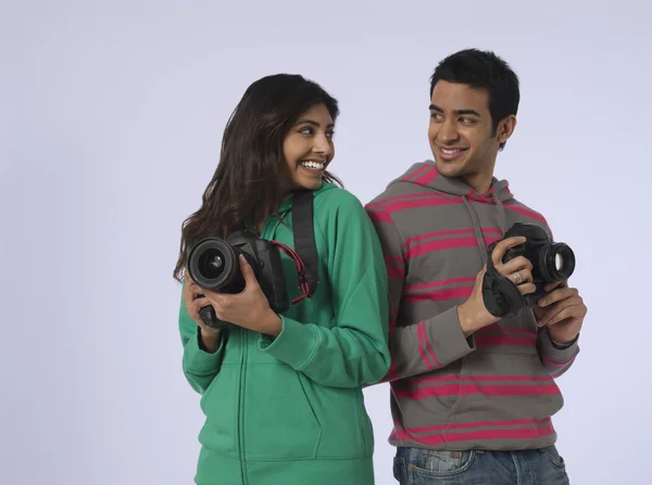 Woman and man holding cameras — Stock Photo, Image