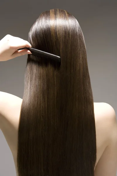 Woman combing hair — Stock Photo, Image