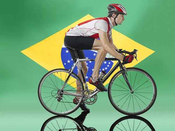 Ποδηλάτη, ποδηλασία μπροστά από την βραζιλιάνικη σημαία — Φωτογραφία Αρχείου