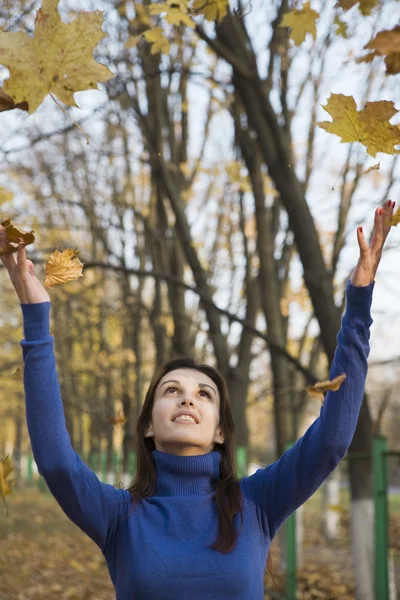 Woman under falling leaves — Stock Photo, Image