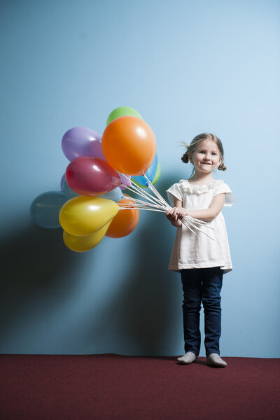 Girl holds bunch of balloons