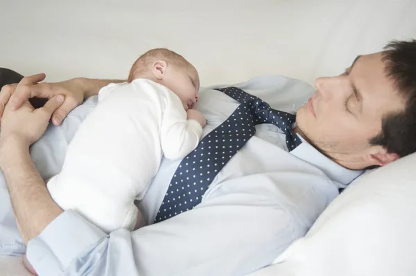 Working father lies sleeping with two week old — Stock Photo, Image