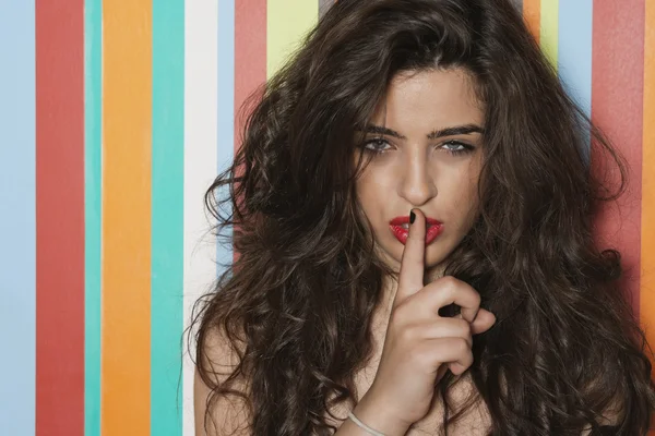 Verleidelijke vrouw met vinger op lippen — Stockfoto