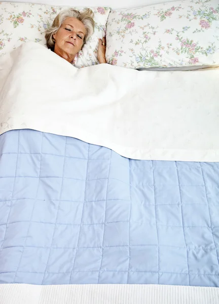 Старшая женщина спит в постели — стоковое фото