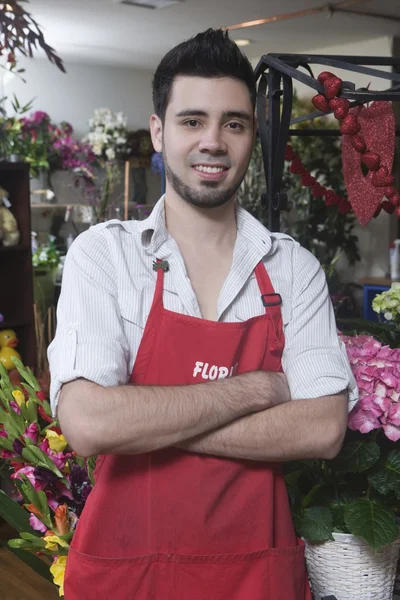 Fleuriste se tient avec les bras pliés — Photo