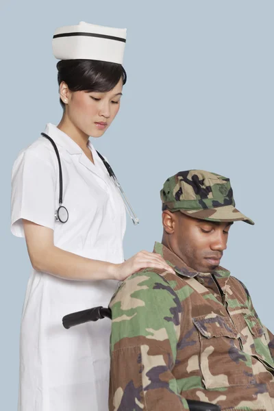 Nurse comforting disabled soldier in wheelchair — Stock Photo, Image