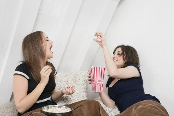 Vrouwelijke gooien popcorn in bed — Stockfoto