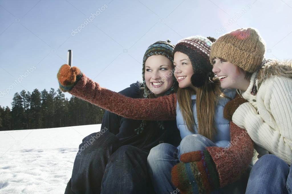 Three girls take self portrait with camera phone