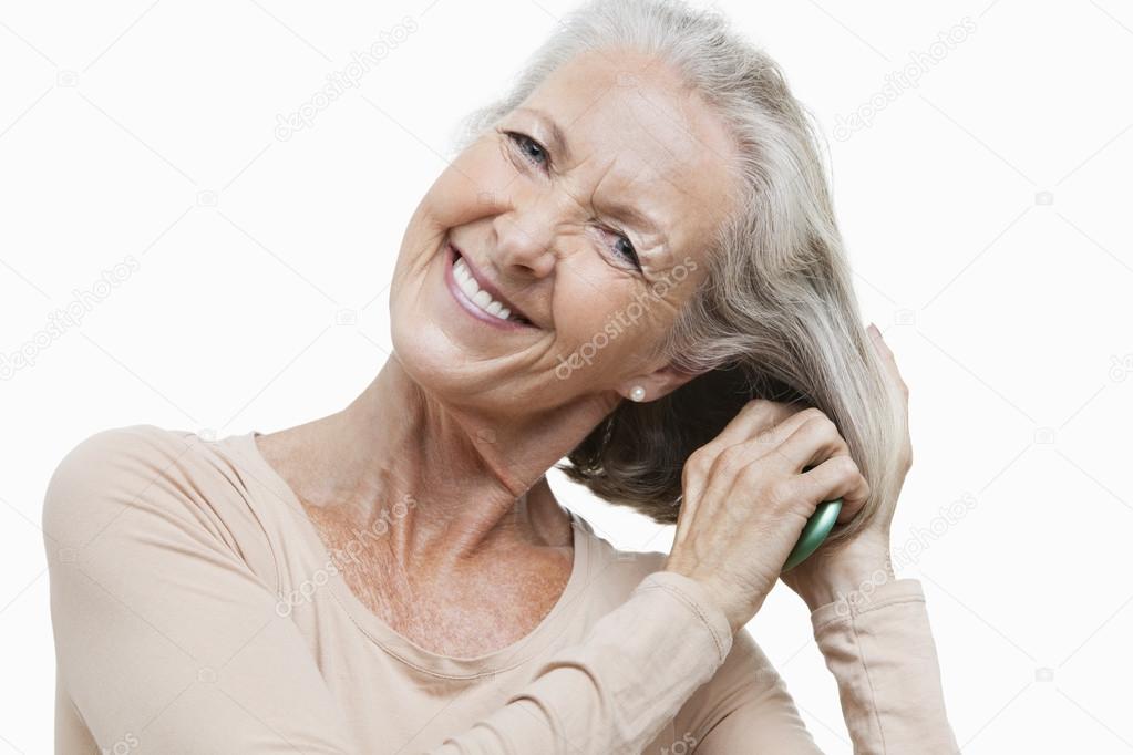 Senior woman combing her hair