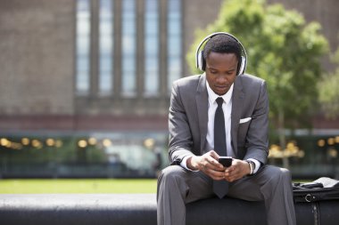 African American Businessman listening music clipart