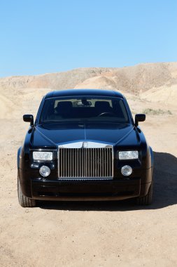 rolls royce önden görünümü asfaltsız yol park etmiş.