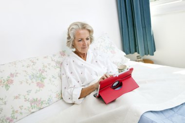 Dijital tablet kullanan yaşlı kadın