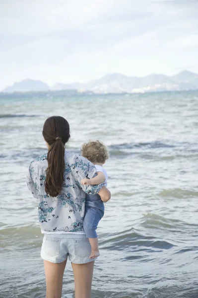 Matka drží své dítě na pláži — Stock fotografie