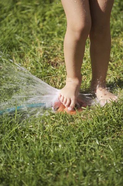女孩用草坪洒水器 — 图库照片
