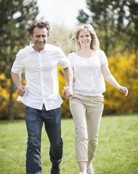 Couple running through park — Stock Photo, Image