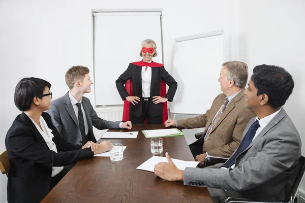 Företagsledare som superhjälte framför kollegor — Stockfoto