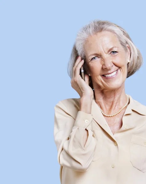 Lachende senior vrouw met behulp van mobiele telefoon — Stockfoto