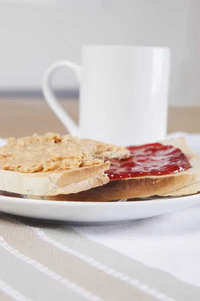 Peanut butter with jam on toasts with coffee — Stock Photo, Image