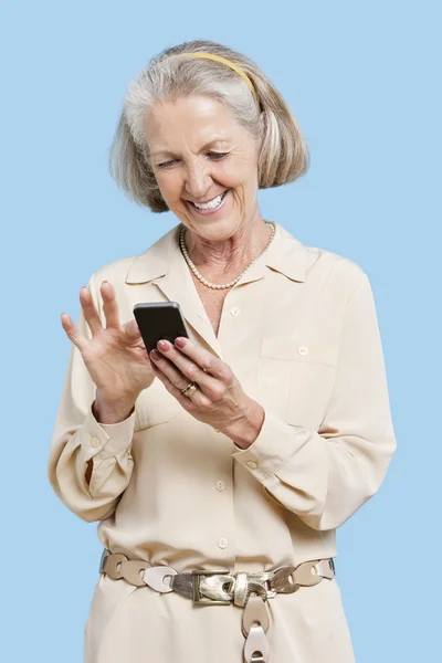 Улыбающаяся пожилая женщина читает смс — стоковое фото