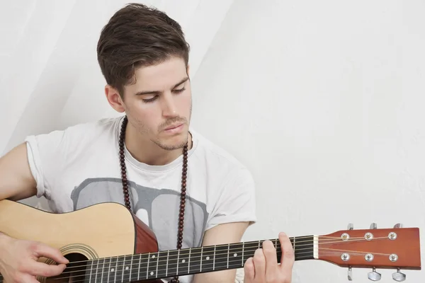 Ung kaukasiska man spela gitarr — Stockfoto