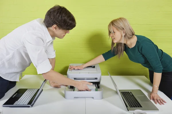 Geschäftsleute richten Drucker mit Laptops ein — Stockfoto