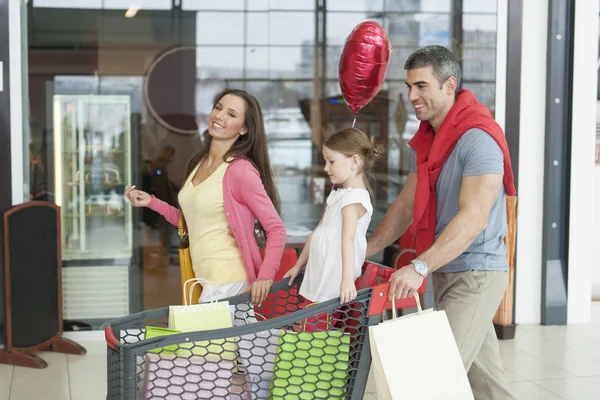 Vater und Mutter schieben kleine Tochter in Einkaufswagen — Stockfoto