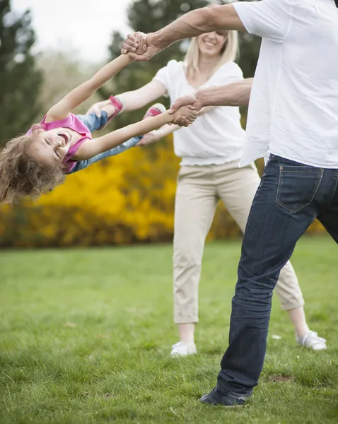 Couple swinging daughter between them — Stock Photo, Image