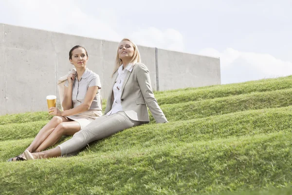 Podnikatelky sedět na trávě — Stock fotografie