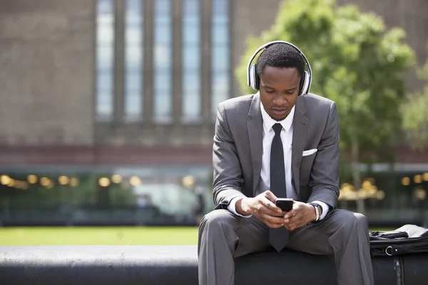 Афроамериканский бизнесмен слушает музыку — стоковое фото