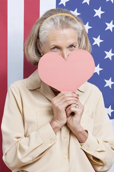 Femme âgée avec coeur en papier rouge — Photo