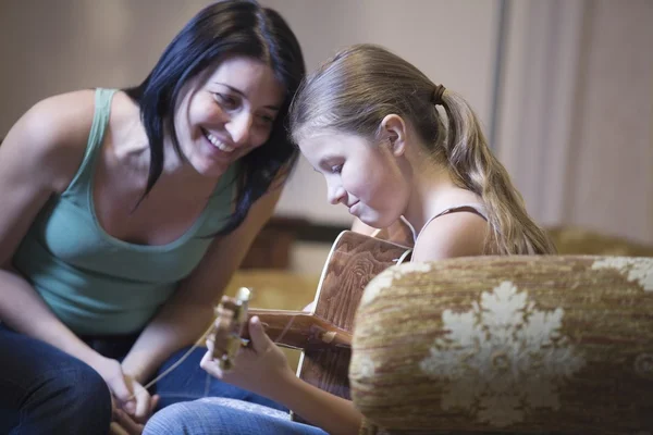 Women encourages young girl with the guitar — Stock Photo, Image