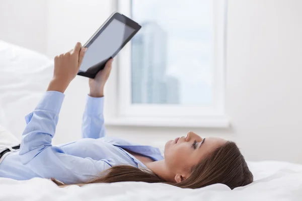 Женщина с планшетным компьютером на кровати — стоковое фото
