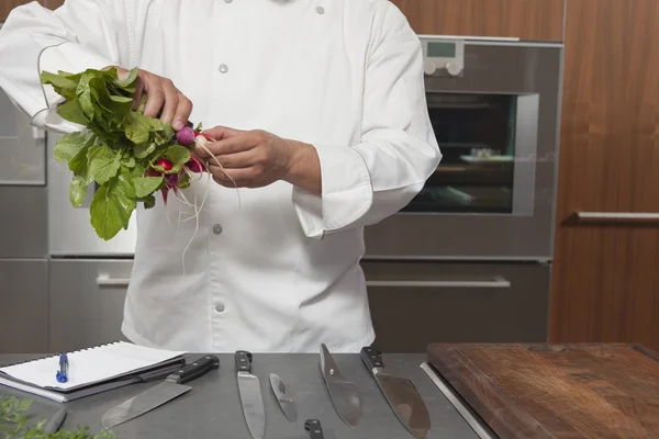 Chef preparing radishes at kitchen — Stock Photo, Image