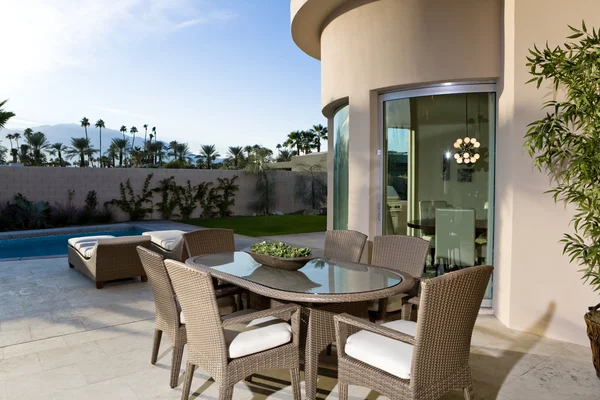 Table on patio by swimming pool — Stock Photo, Image