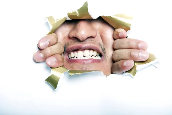 Man looking through ripped paper hole — Stock Photo, Image