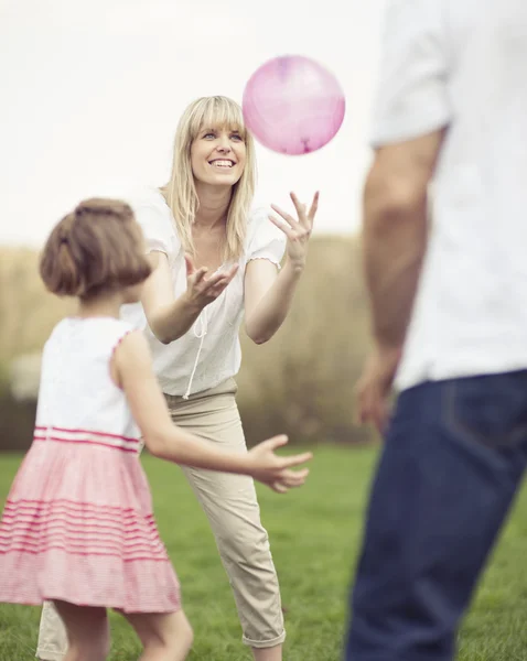 Father mother and daughter throwing ball — Stock Photo, Image