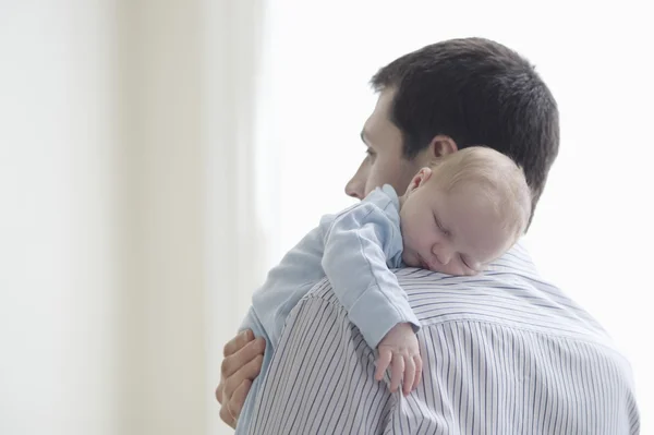 Father holds newborn on shoulder — Stock Photo, Image