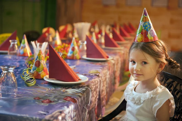 Chica sentada en la mesa de cumpleaños — Foto de Stock